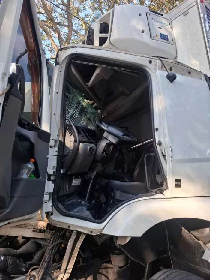 Caminhão colide na traseira de veículo estacionado e motorista fica preso às ferragens em Alfenas