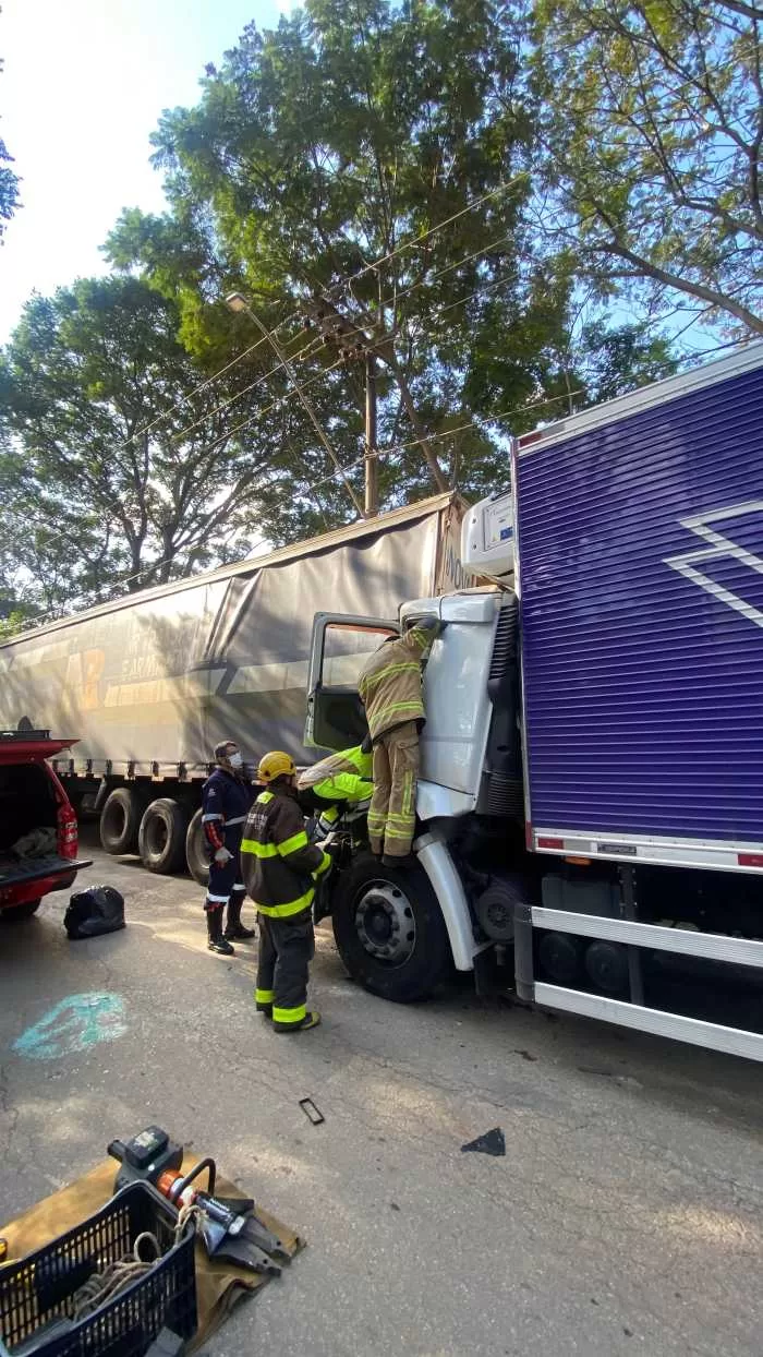 Caminhão colide na traseira de veículo estacionado e motorista fica preso às ferragens em Alfenas